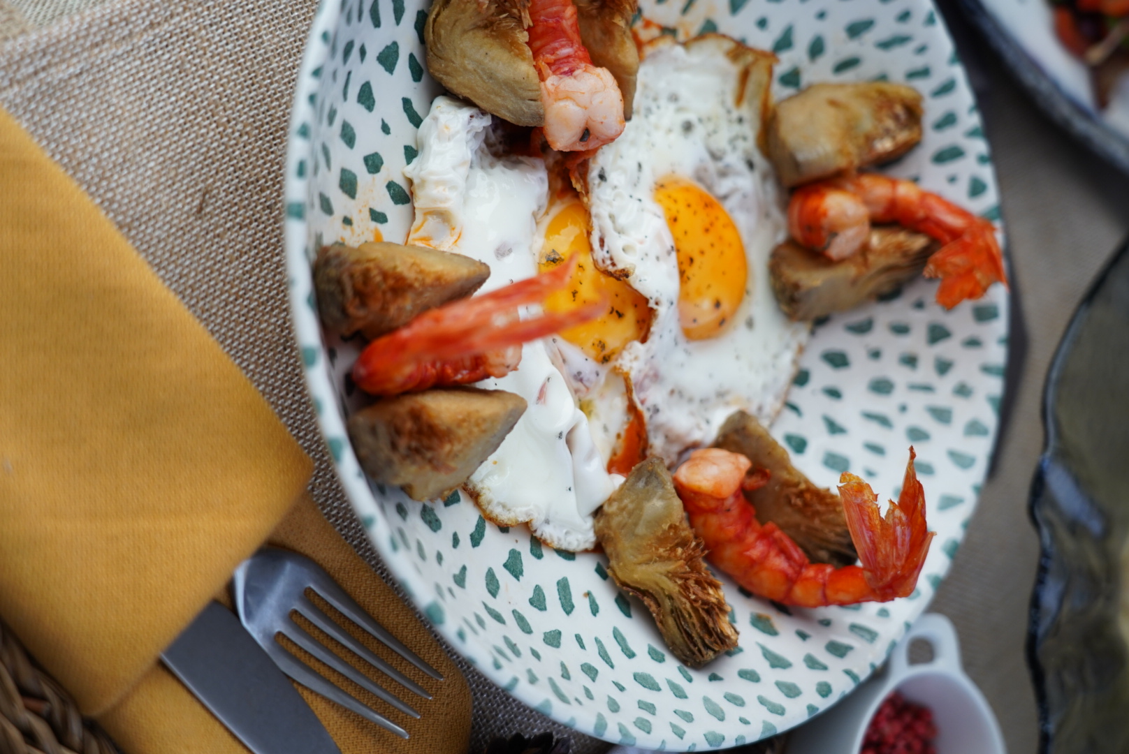 Huevos rotos de alcachofas y carabineros